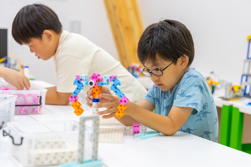 アドバンスクラスでモーターを使ったロボットを組み立てる小学生