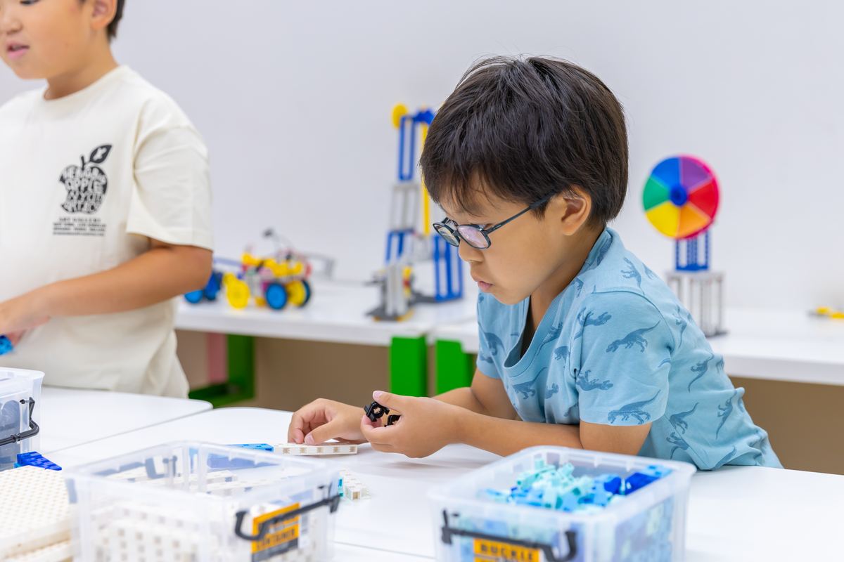ブロックとモーターで作った作品を調整する小学生