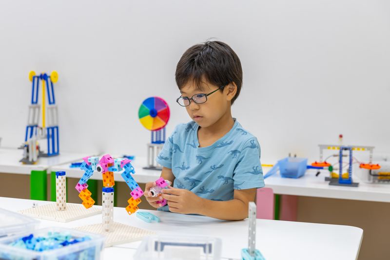 作品を見ながら次の工夫を考える小学生