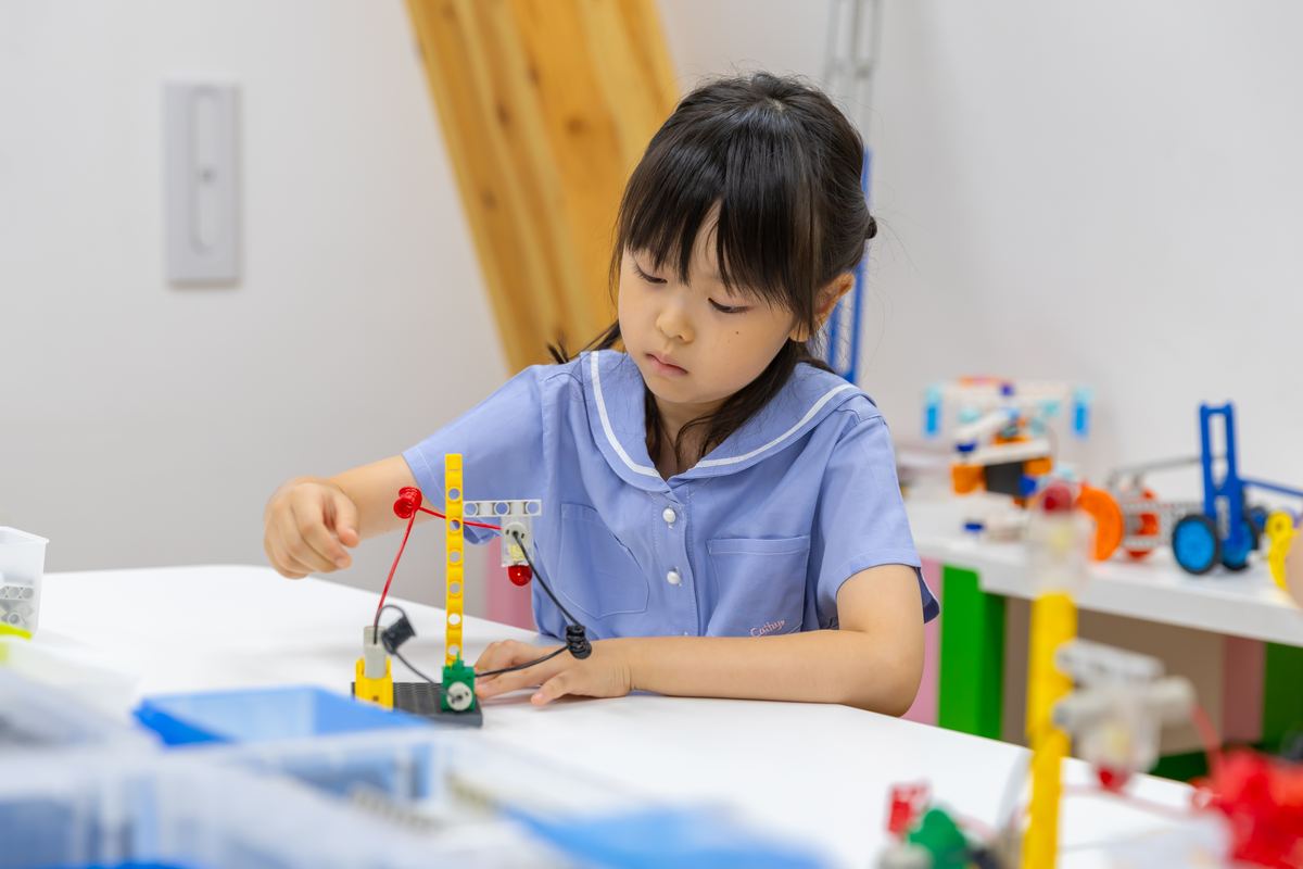 ブロックを組み合わせて自分の作品をつくる小学生