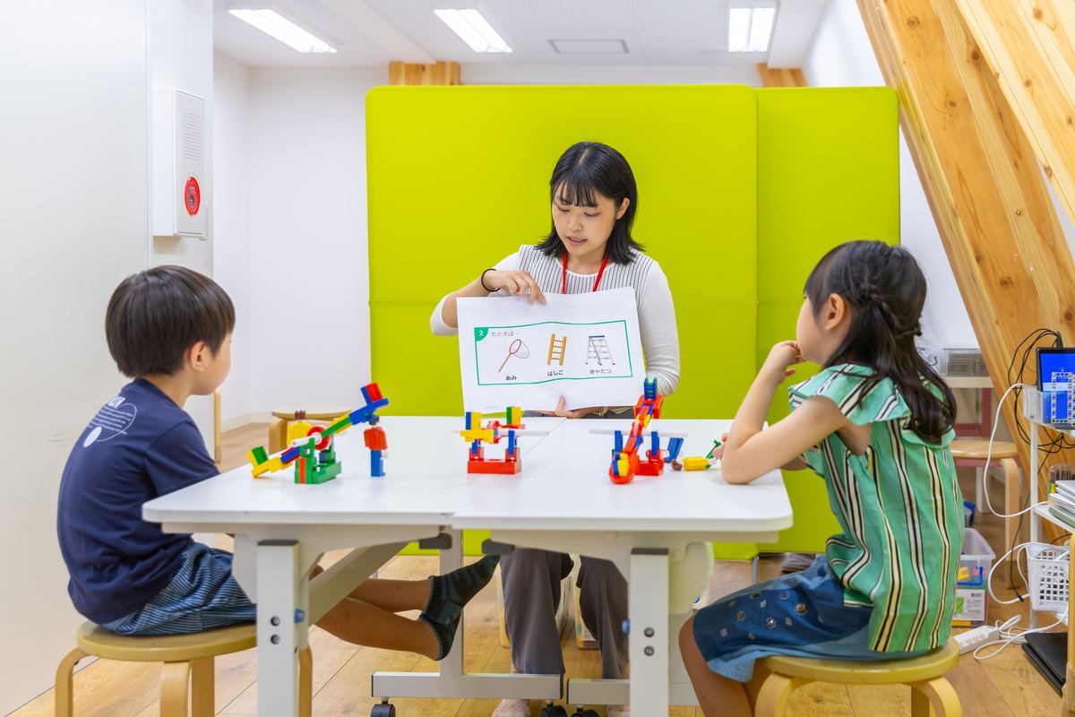 先生と一緒にブロックのしくみを考える子どもたち