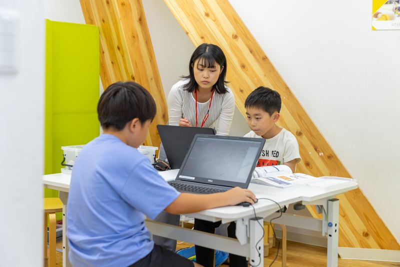 パソコンでロボットを動かすプログラムに取り組む小学生