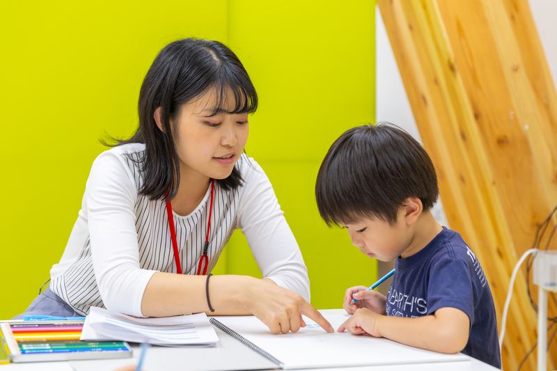 鉛筆で問題を絵に表して考える小学生